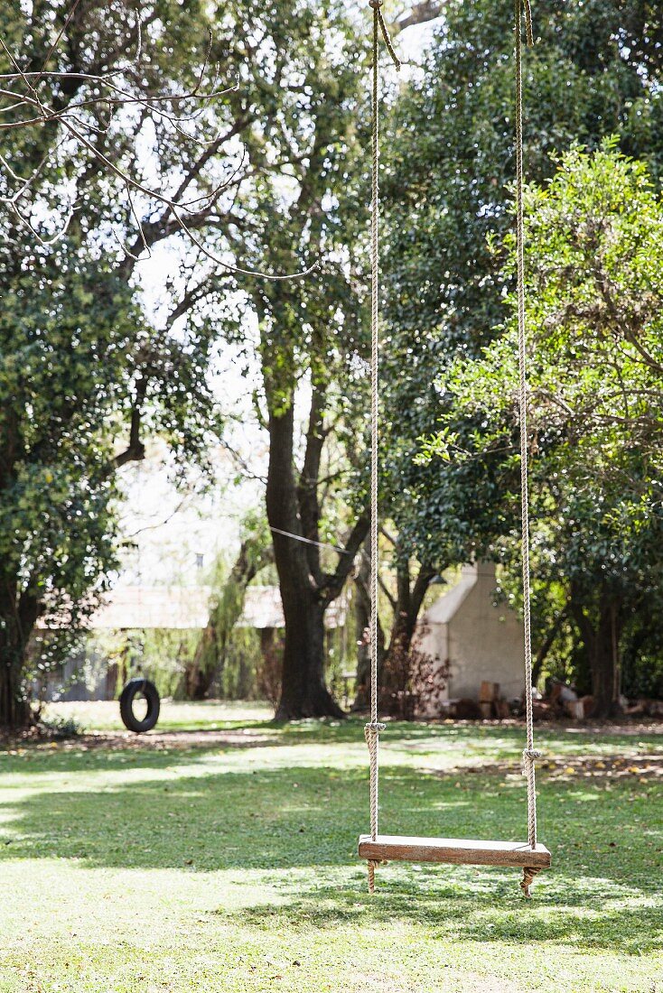 Swing in garden with mature trees