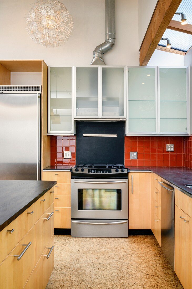 Blick auf Herd und Hängeschränke in moderner Küche mit Schrankfronten in heller Holzoptik