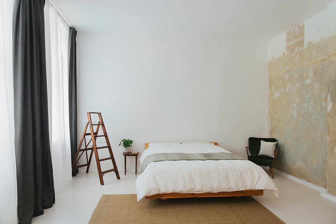 Minimalistisches Schlafzimmer, eine Wand mit alten Farbschichten