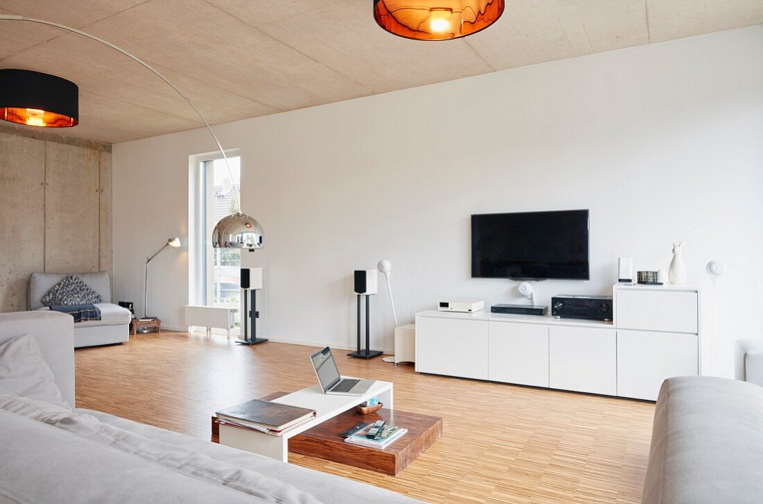 Modernes Wohnzimmer mit Holzboden und Betondecke