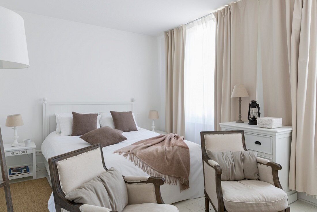 Elegantes Landhaus-Schlafzimmer mit Armlehnsesseln