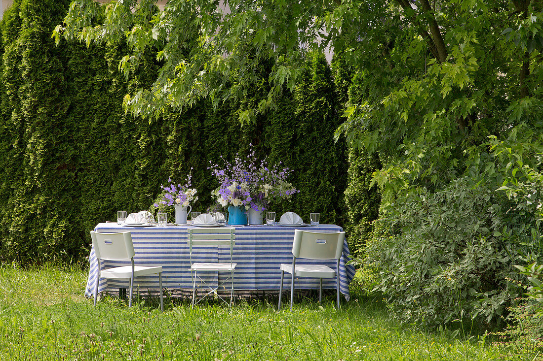 Table festively set in blue and white in summer garden