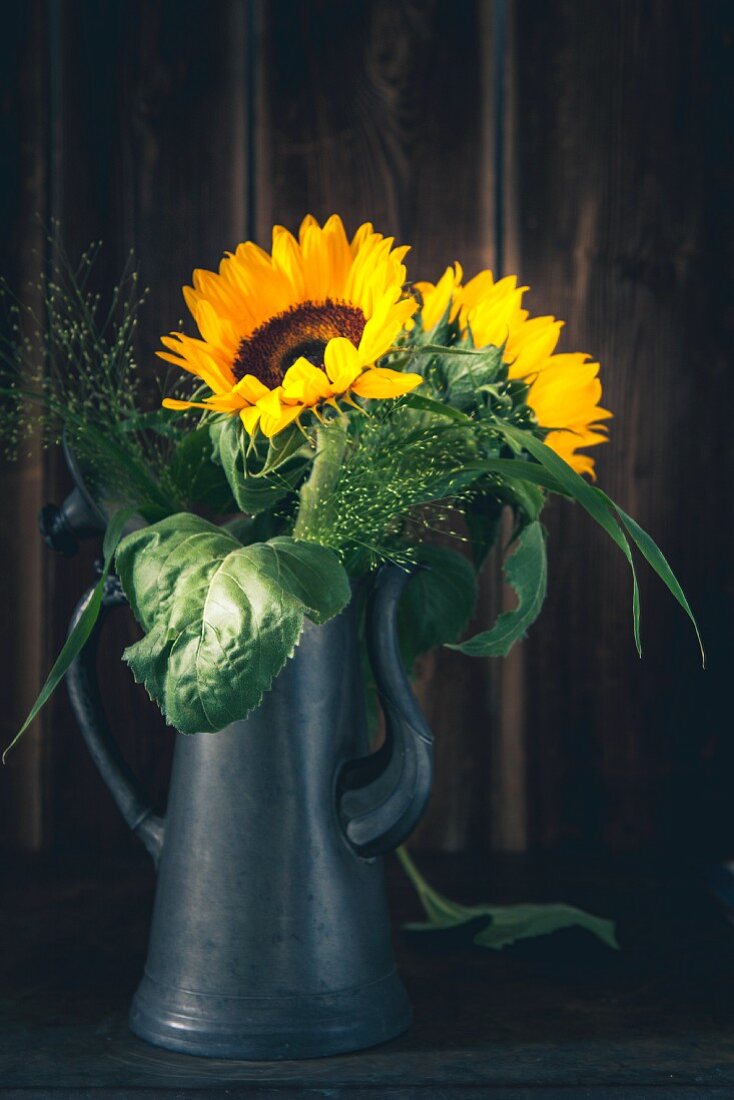 Sonnenblumen in einer Kaffeekanne aus Metall