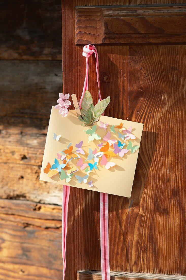 Selbstgebastelte Grußkarte mit kleinen Schmetterlingen aus Papier