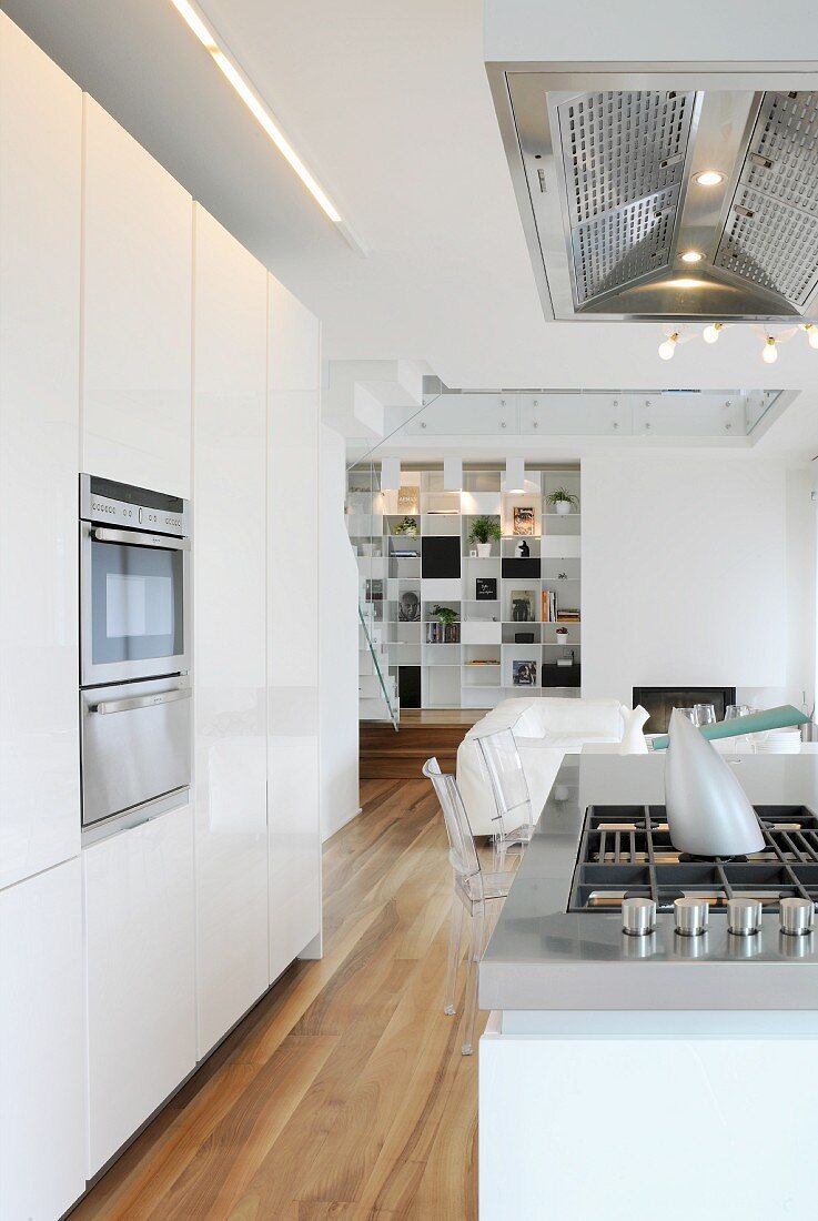 weiße Designerküche mit Kochinsel in offenem Wohnbereich eines Architektenhauses