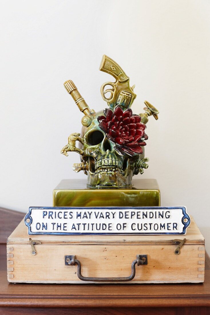 Skull and flower sculpture with sign on old wooden case