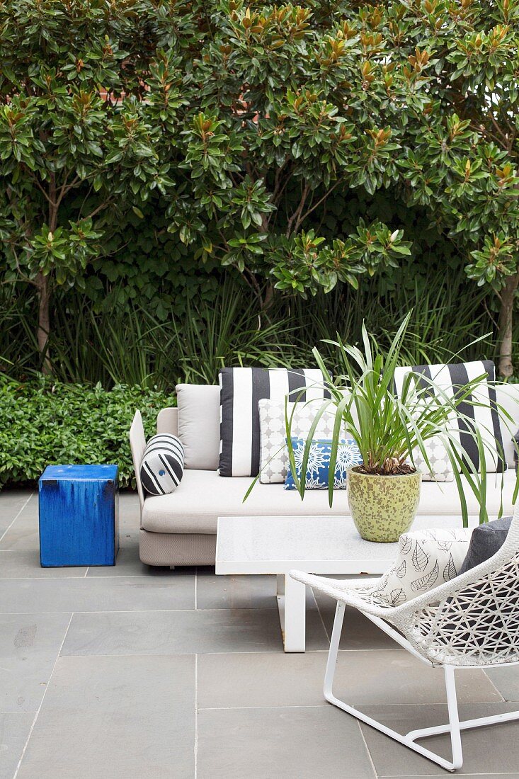 Gemütliche Outdoor-Lounge mit heller Couch auf Terrasse