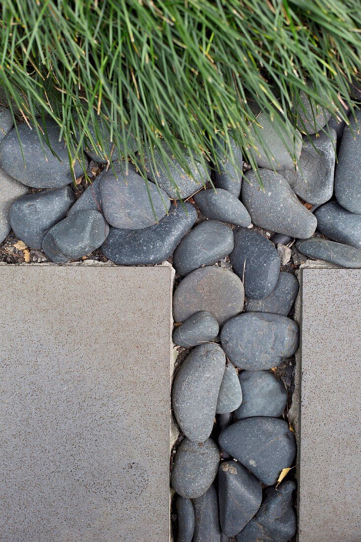 Slabs and pebbles next to ornamental grass