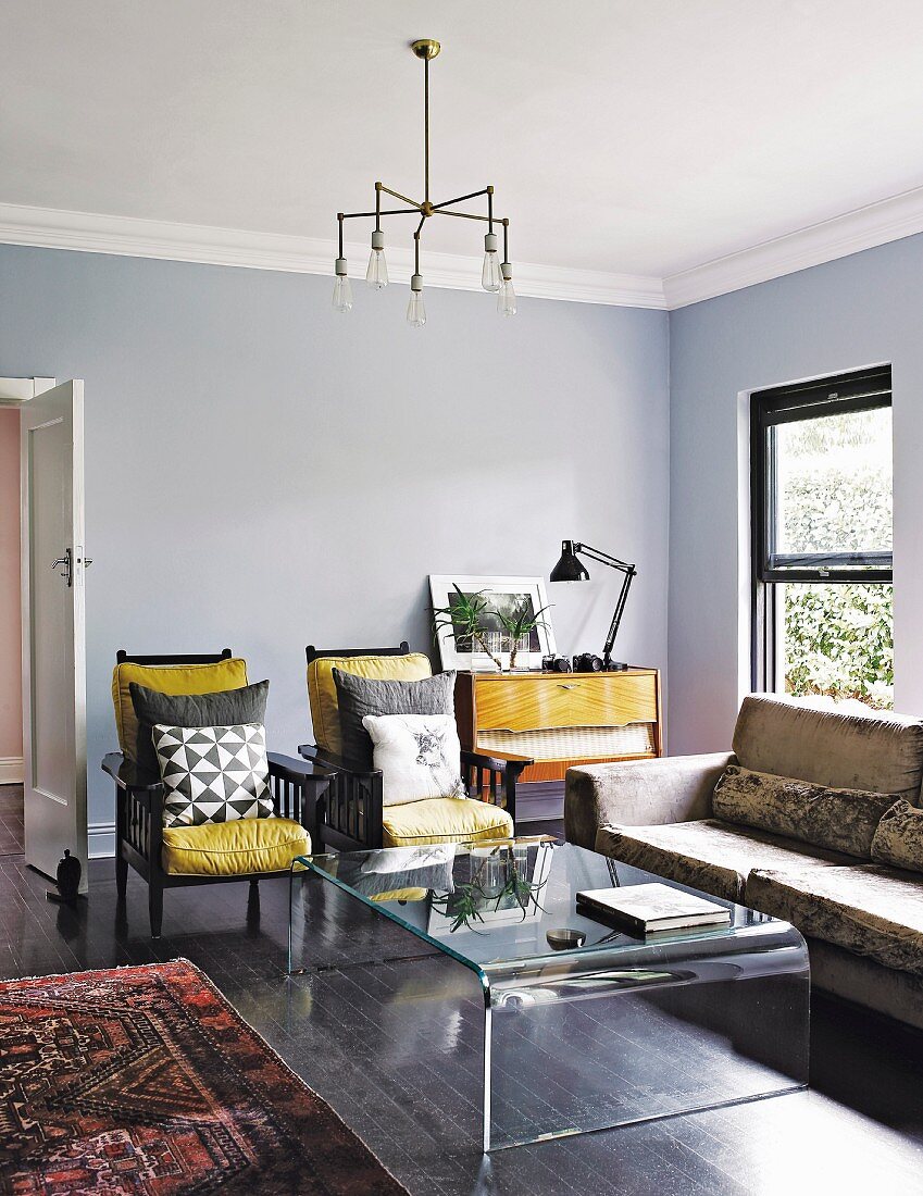 Wohnzimmer mit Möbeln im Stilmix und blaugrauen Wänden