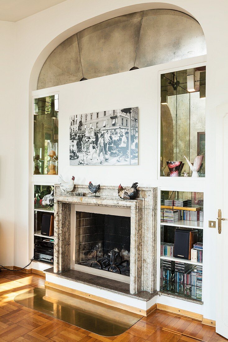 Masonry shelves with mirrored niches surrounding open fireplace