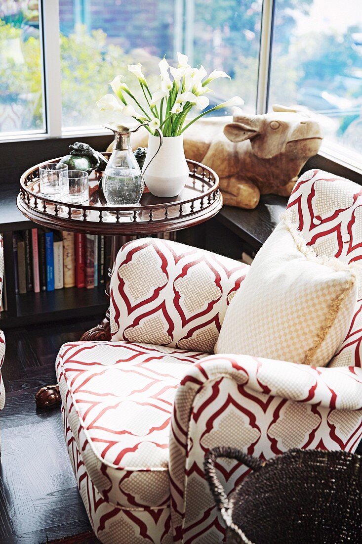 Armchair with patterned upholstery next to windows