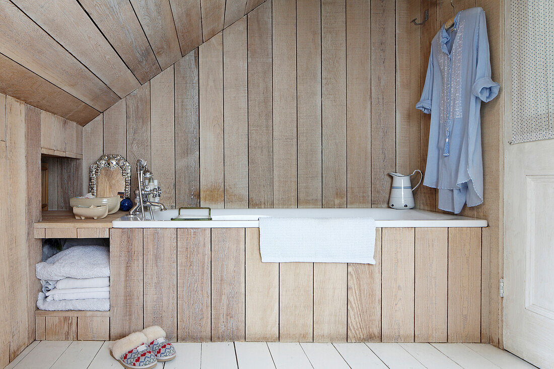 Wood-clad bathtub and walls in bathroom