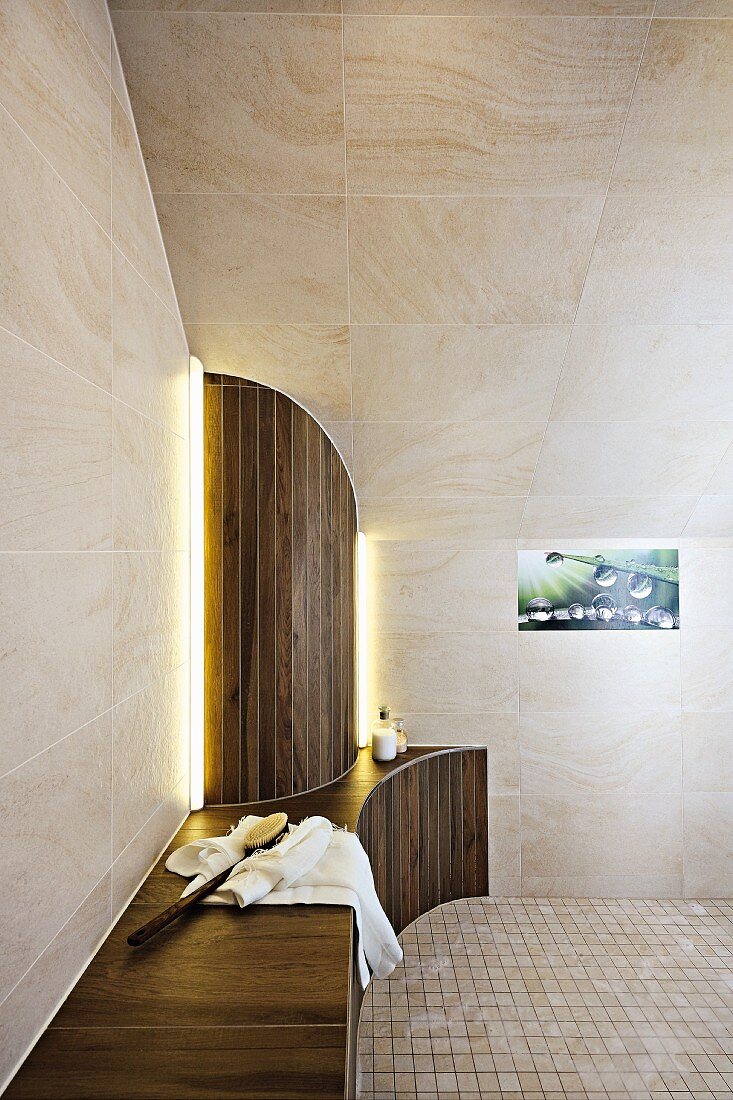 Designer-Bad mit Sitzfläche und halbrunder Verkleidung unter gefliester Dachschräge