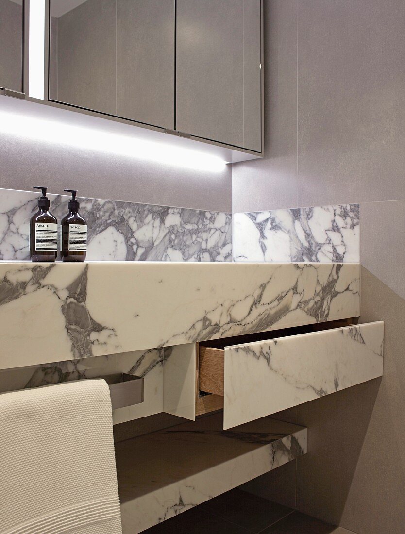 Massgefertigter Waschtisch aus Marmor mit Schublade, oberhalb Spiegelschrank mit indirekter Beleuchtung