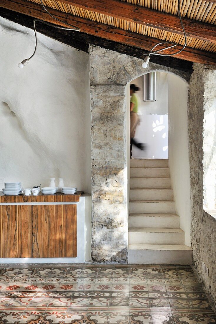 Treppenaufgang mit Segmentbogen und traditioneller Fliesenboden in mediterranem Gebäude