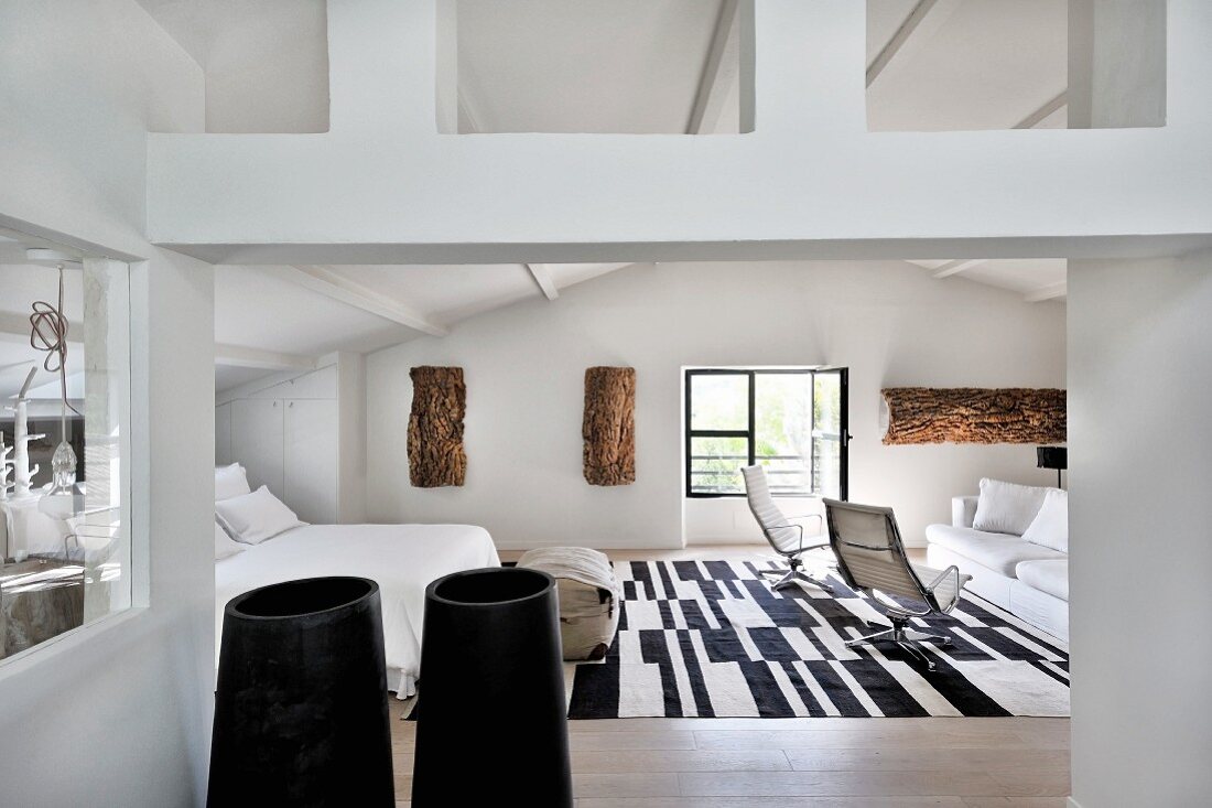 Schlafzimmer mit Lounge und schwarz-weißem Teppich im Dachgeschoss