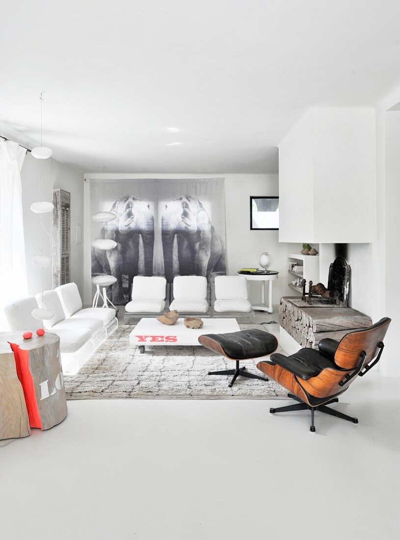 Eleganter Loungebereich mit Designermöbeln und Kaminabzug über rustikaler Feuerstelle