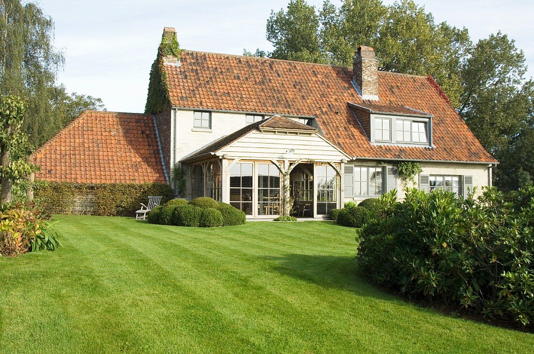 Traditionelles Landhaus mit grüner Rasenfläche