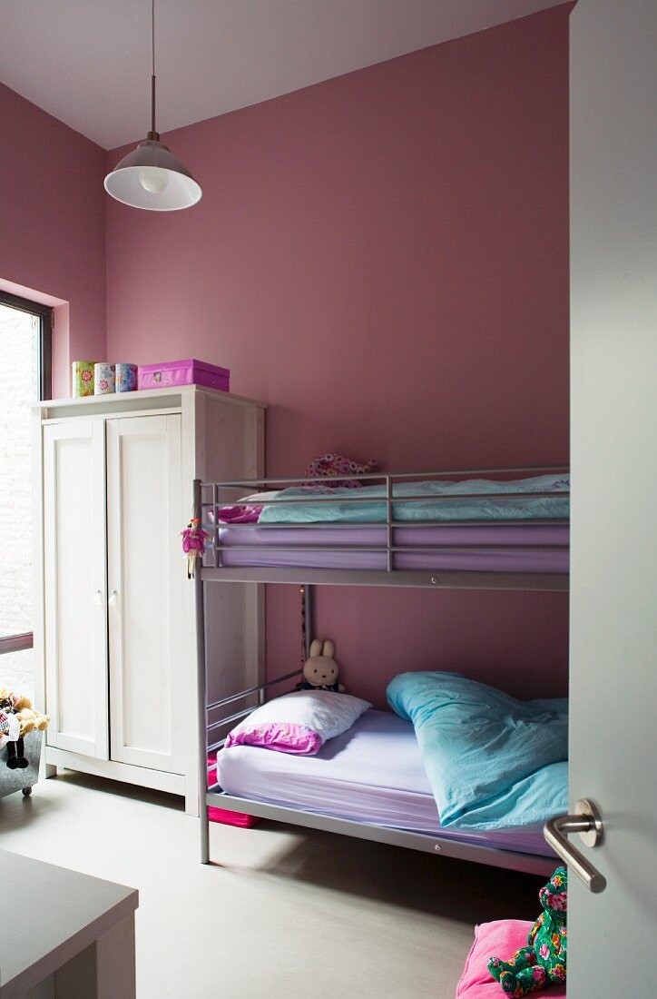Bunk beds and pink walls in children's bedroom