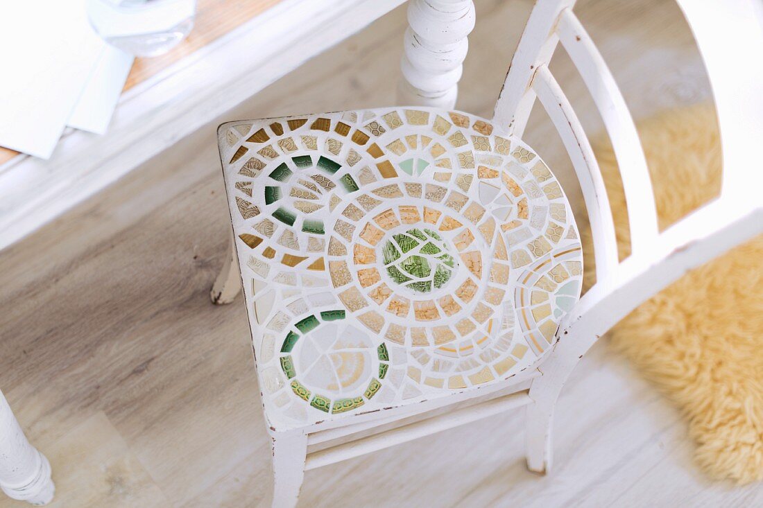 Kreisförmiges Mosaik auf der Sitzfläche eines alten Stuhls
