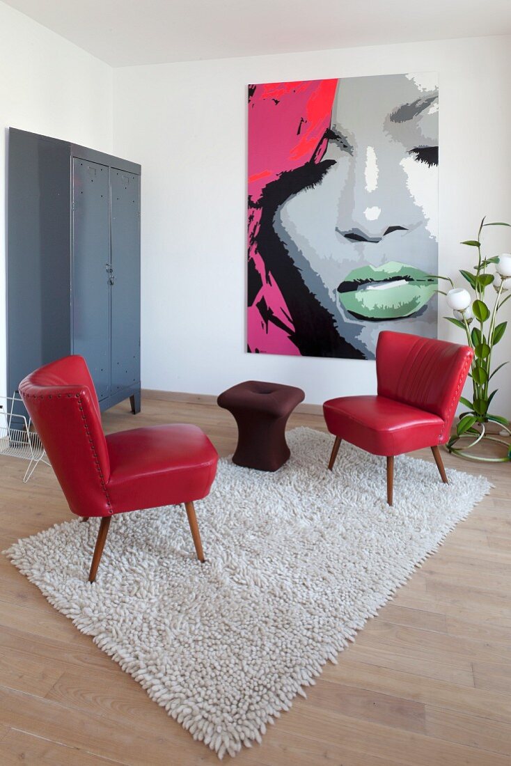 Schlicht eingerichtetes Wohnzimmer mit Retromöbeln und Pop Art Bild