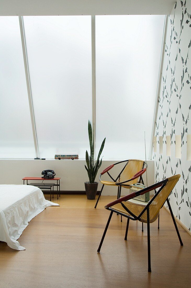 Zwei Retro-Sessel im Schlafzimmer mit blickdichtem Glasdach