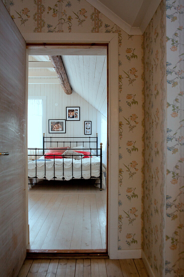 View through door into rustic bedroom with metal-framed bed