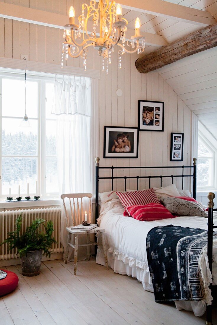 Traditionelles, skandinavisches Schlafzimmer mit Dielenboden und Holzbalkendecke im Dachgeschoss