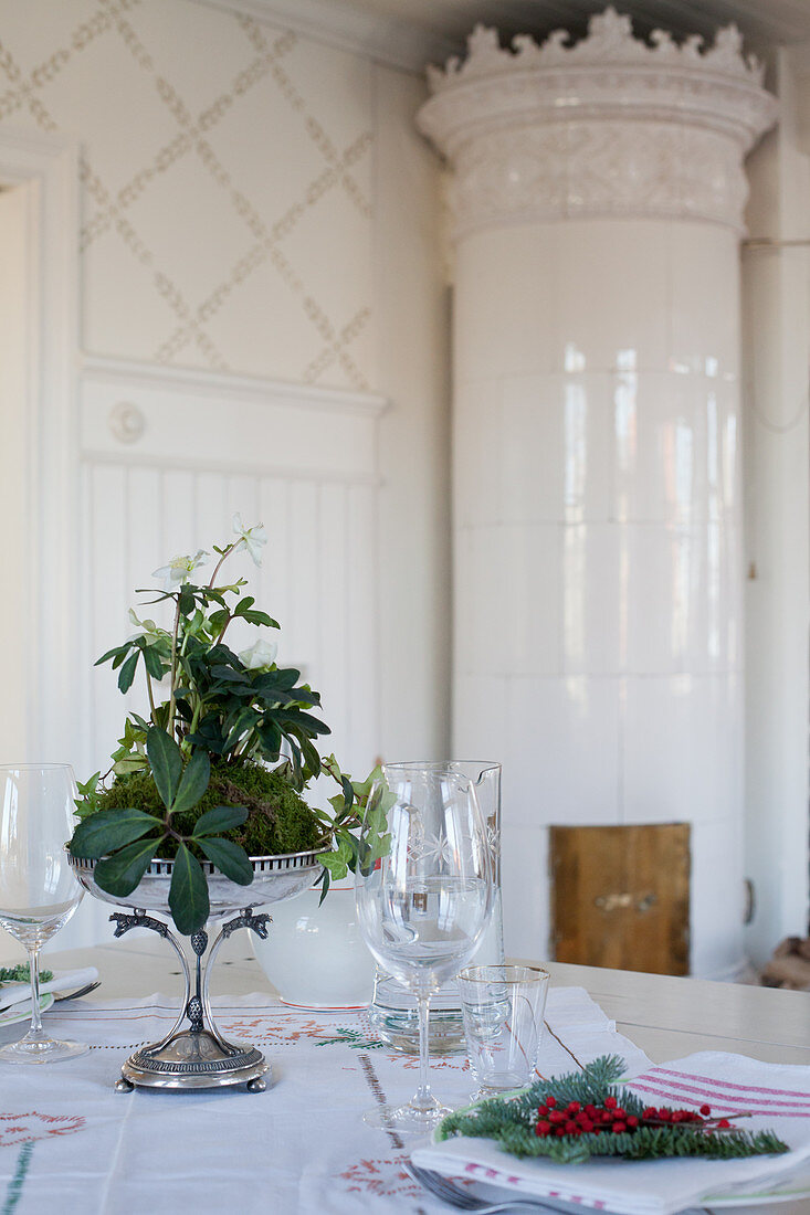 Weihnachtlich gedeckter Tisch vor dem schwedischen Kachelofen
