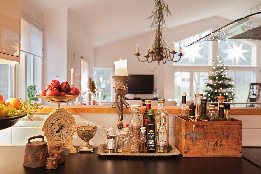 Vintage Küchenutensilien vor Theke, im Hintergrund Wohnzimmer mit geschmücktem Weihnachtsbaum