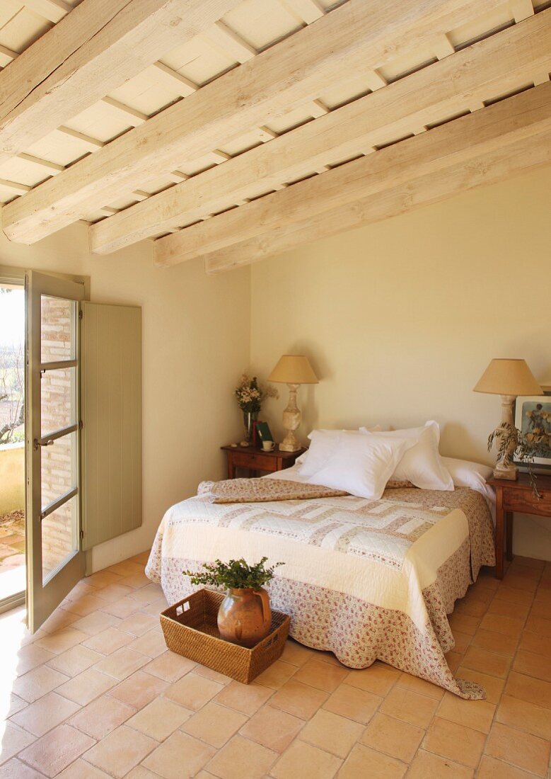 Mediterranes Schlafzimmer mit Balkendecke und Terracottaboden
