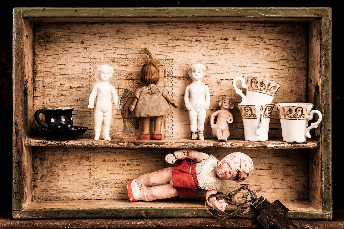 Antike Puppen und Geschirr in Holzkasten