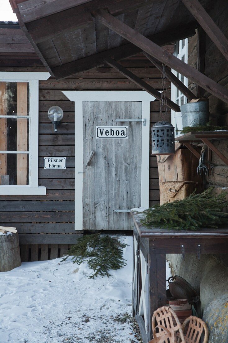 Holzhaus in Schweden mit Schnee und Tannengrün vor der Tür