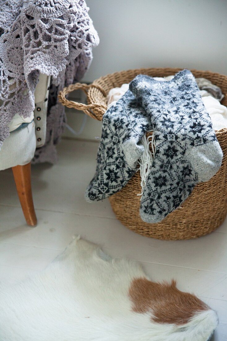 Thick woollen socks with Norwegian pattern lying on basket