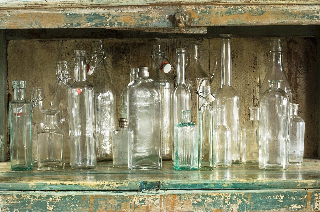Verschiedene Glasflaschen in einem rustikalen Küchenschrank