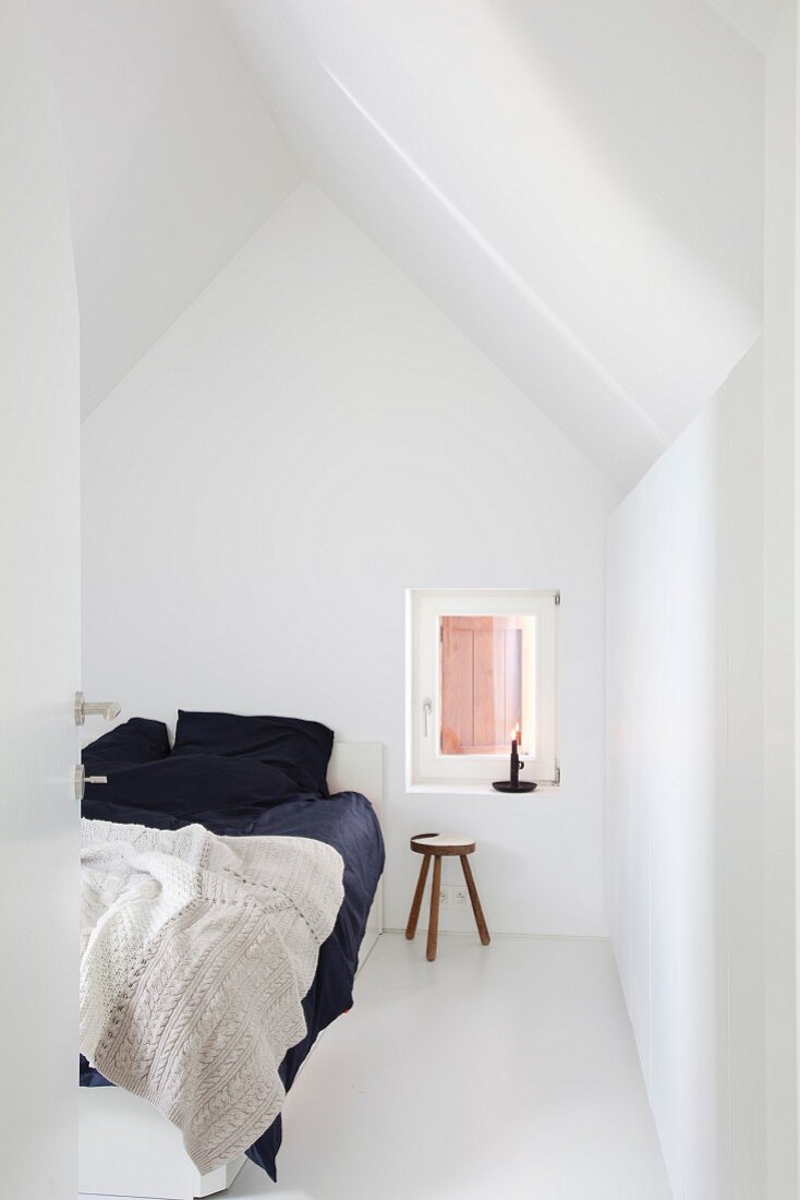 Black bed linen on double bed in white bedroom