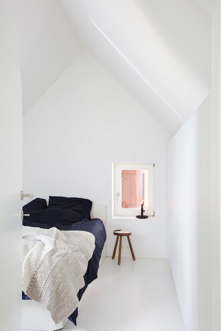 Weisses Schlafzimmer mit Doppelbett und schwarzer Bettwäsche