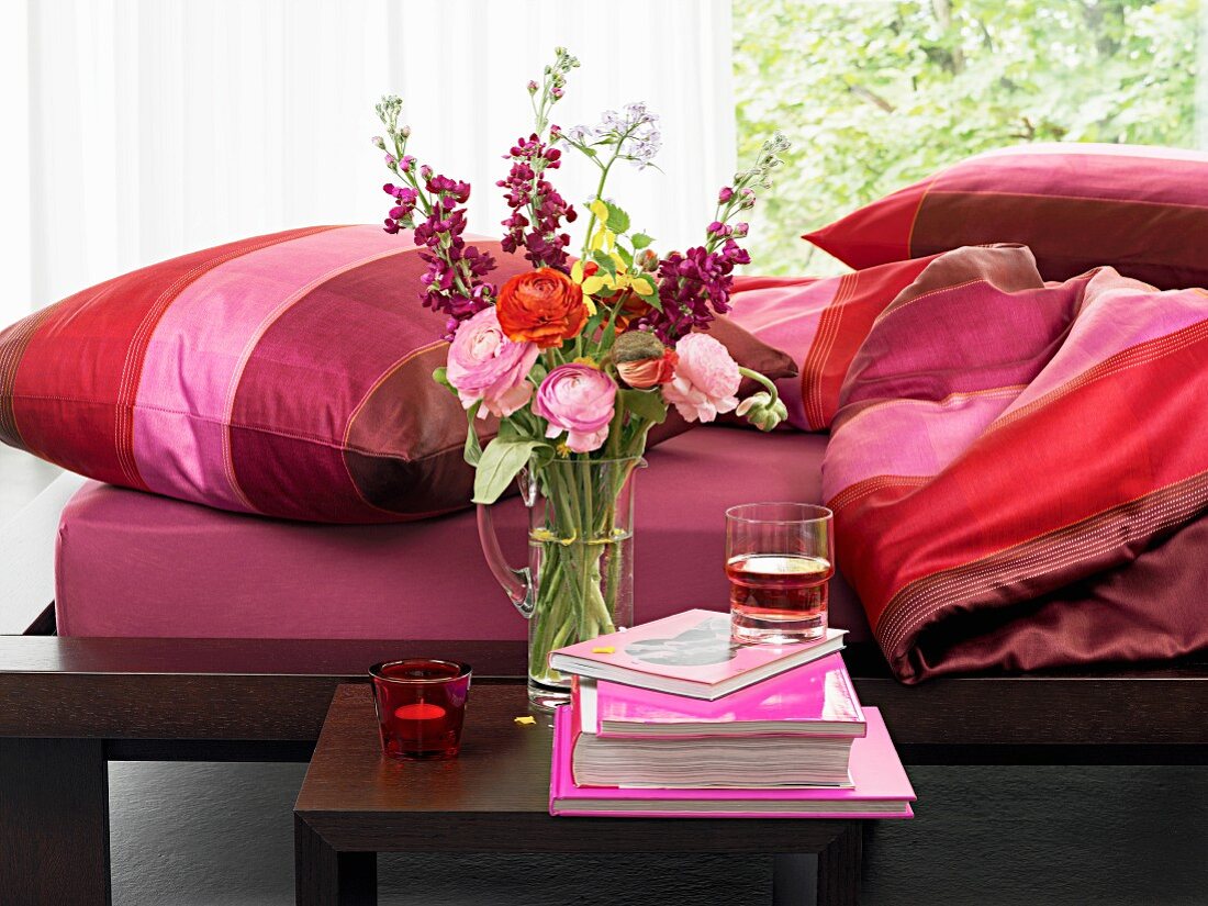 Rote Farbakzente im Schlafzimmer, Blumen auf dem Nachttisch