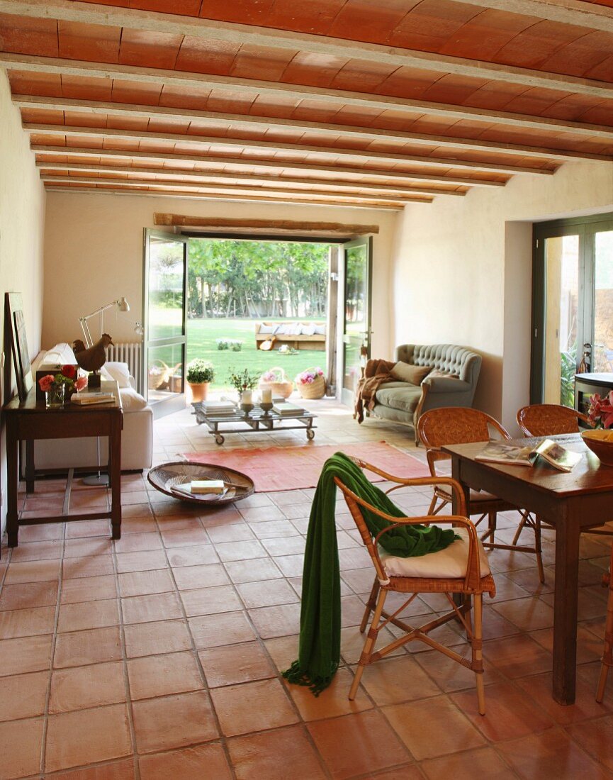 Mediterraner Wohnraum mit Essbereich und Couch auf Terrakottafliesenboden