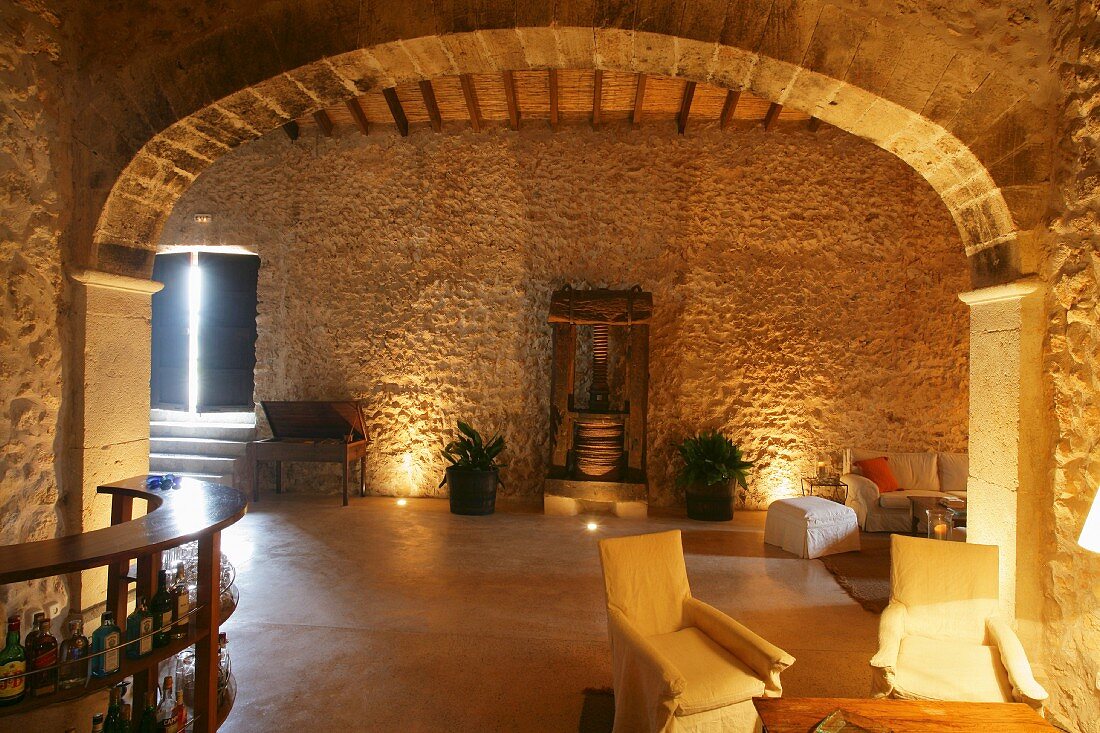Mediterranes Wohnzimmer mit Natursteinwand und Bogen
