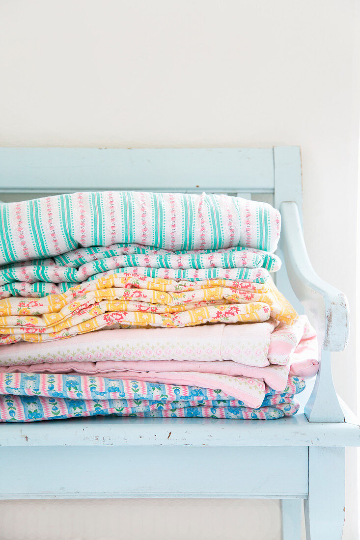 Stacked linen on pale blue wooden bench