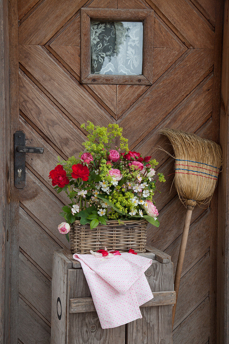 Rosengesteck mit Frauenmantel im Korb vor Haustür