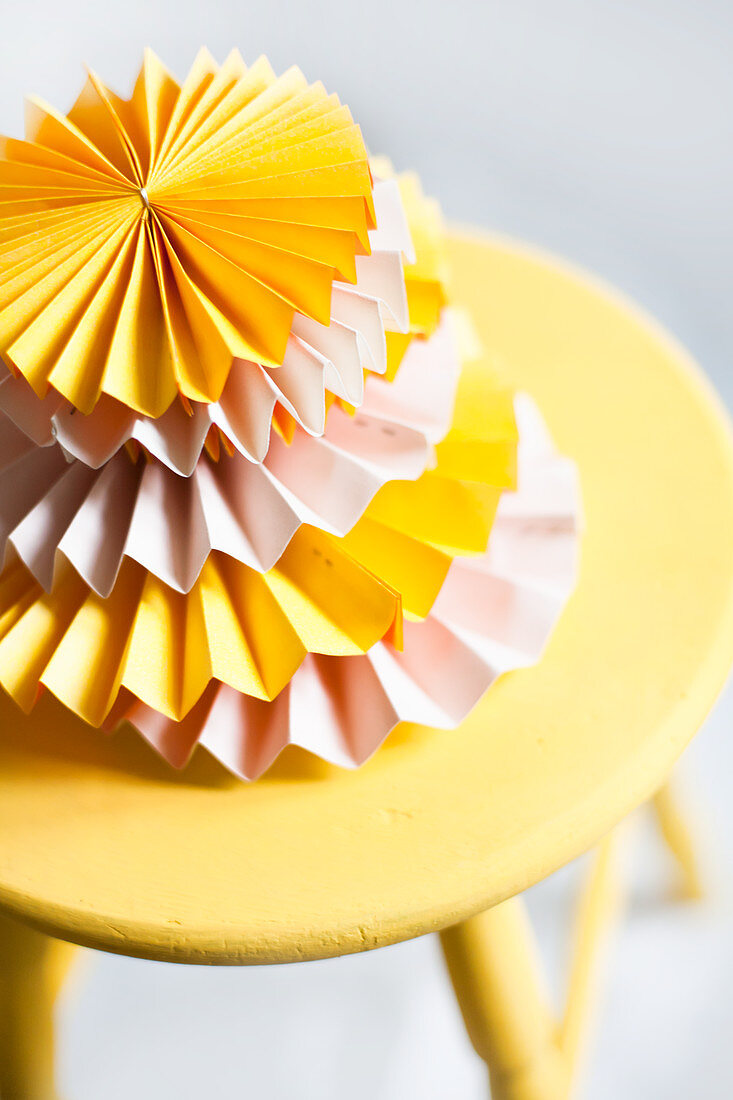 Stack of alternating pink and yellow paper rosettes