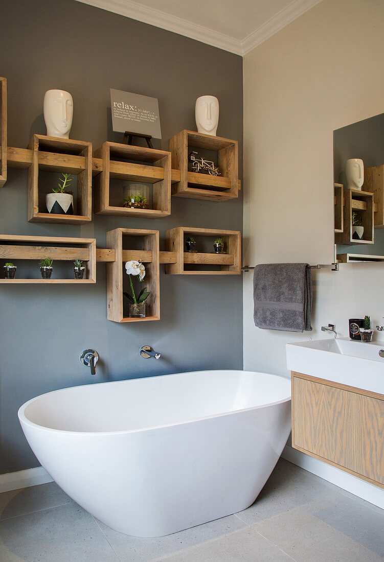 Shelves made from wooden crates on grey wall in bathroom