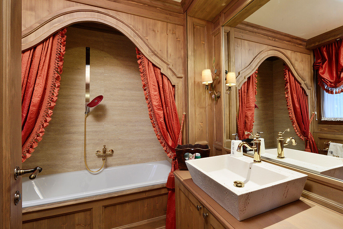 Opulent bathroom with red curtains on bathtub