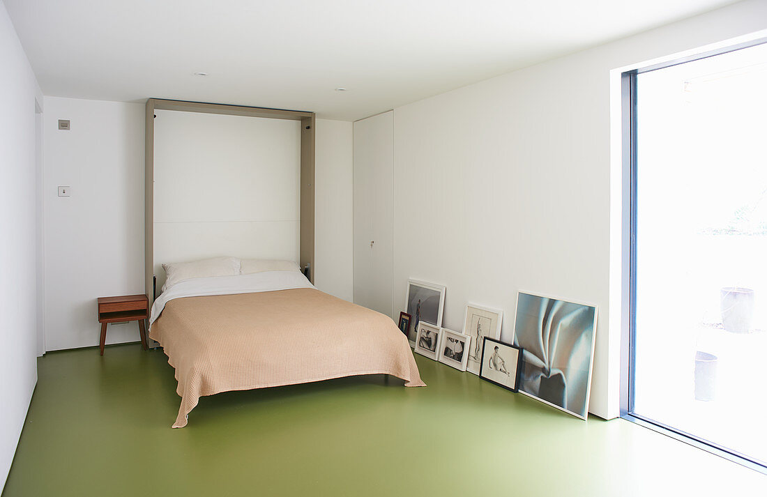 Klappbett im minimalistischen Raum mit grünem Boden