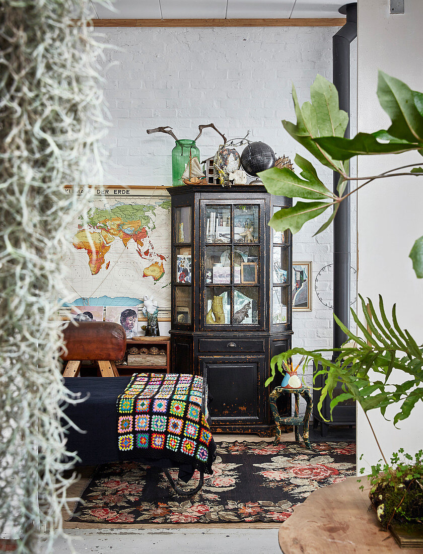 View into vintage-style bedroom through houseplant leaves
