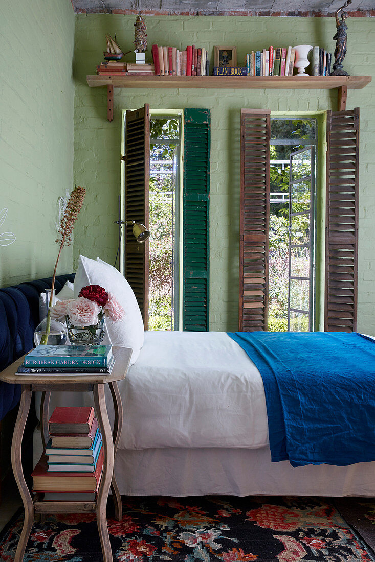 Green brick walls and tall narrow windows in bedroom