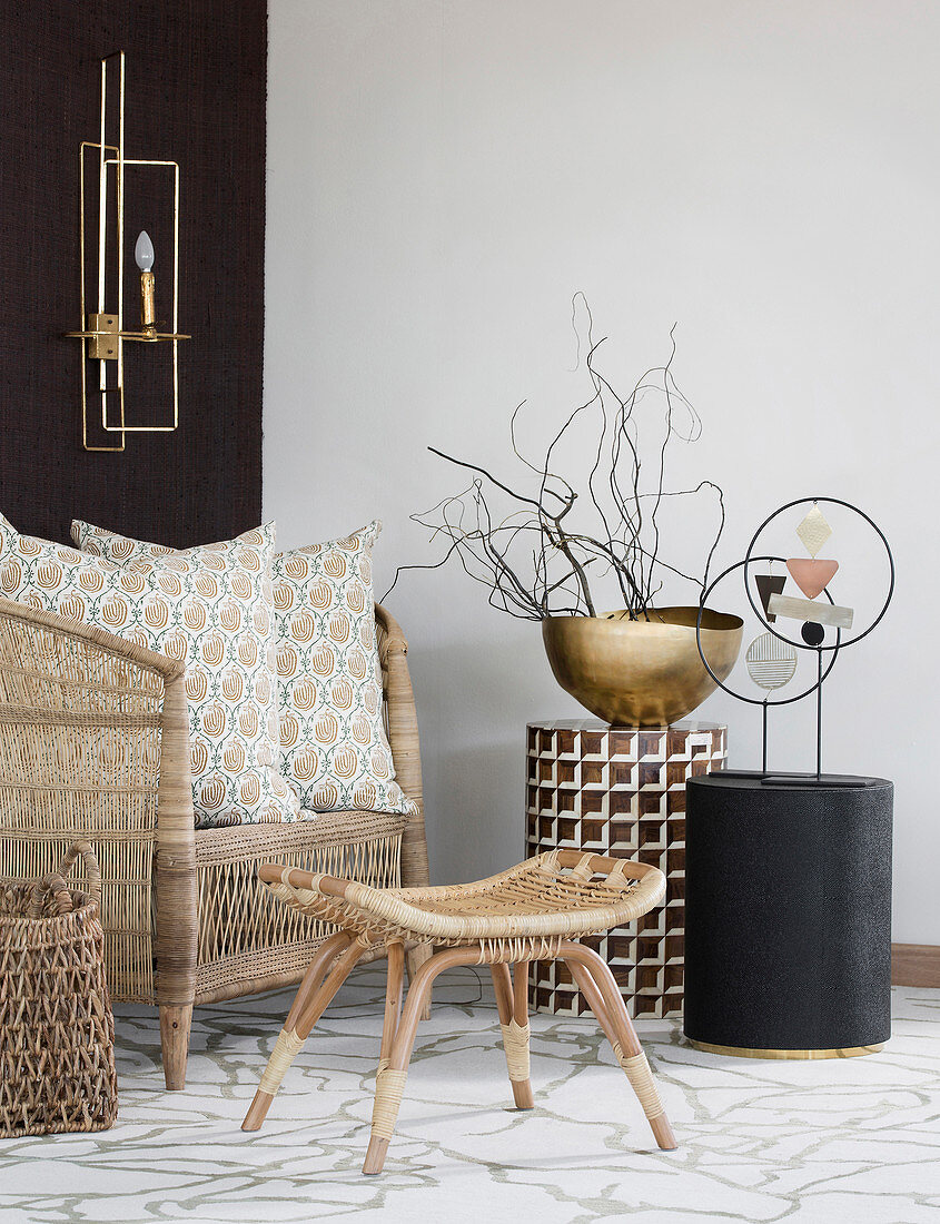 Wicker armchair and small side tables in natural shades in seating area