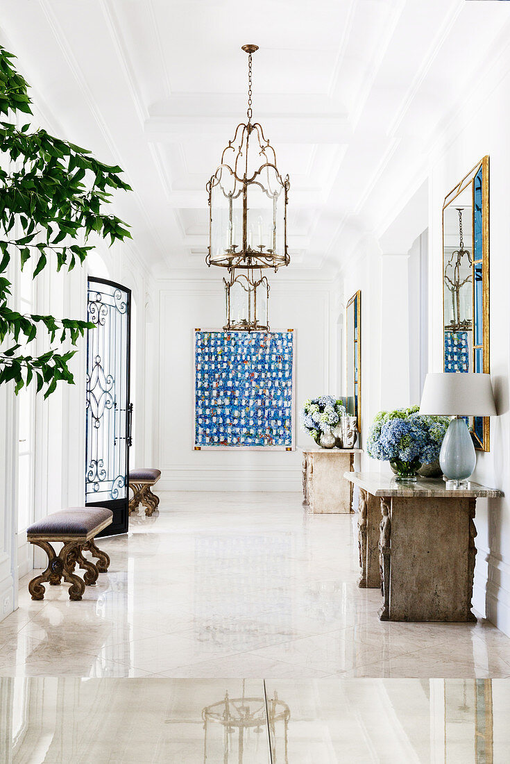 Elegant entrance hall with benches, console table and artwork